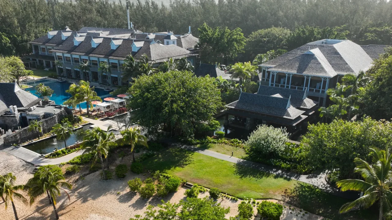 elevated image of beachfront resort buildings surrounded by tropical greenery