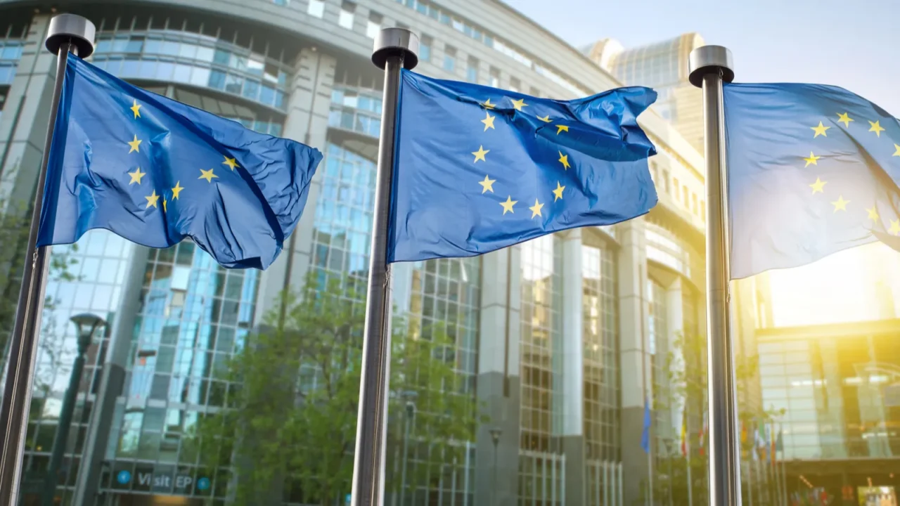 european union flag against parliament in brussels