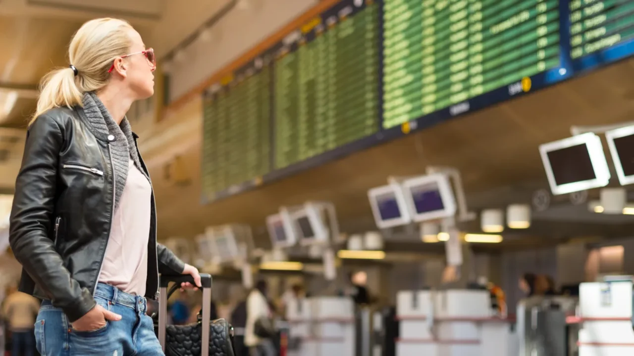 female traveller checking flight departures board