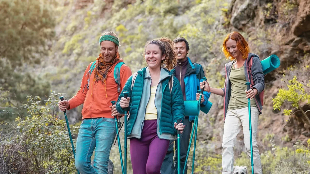group of friends with backpacks doing trekking excursion on mountain