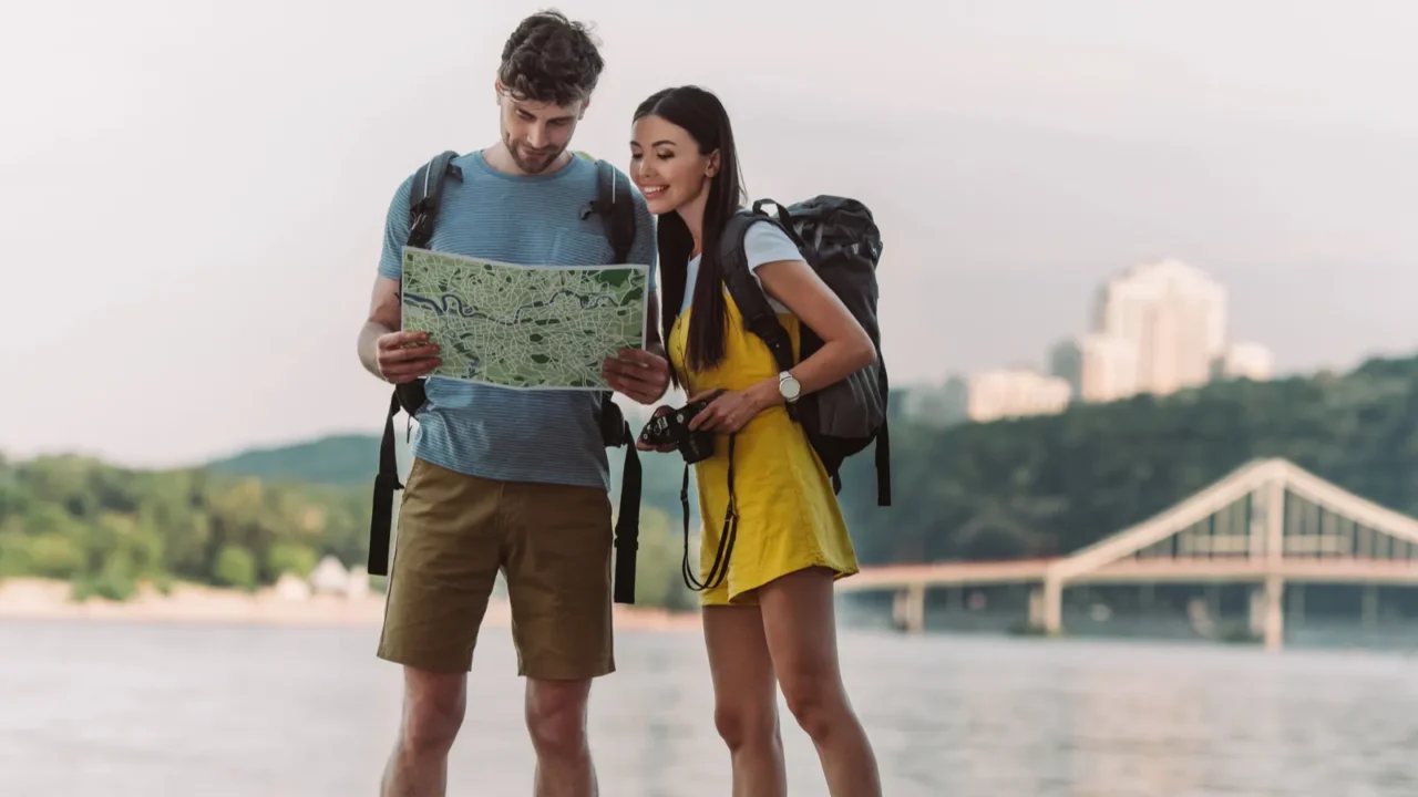 handsome man and asian woman in overalls looking at map