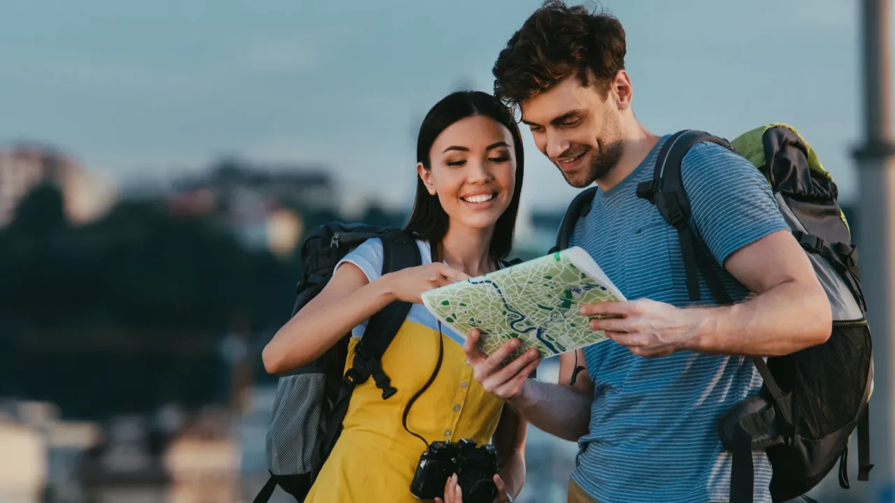 handsome man and asian woman smiling and looking at map