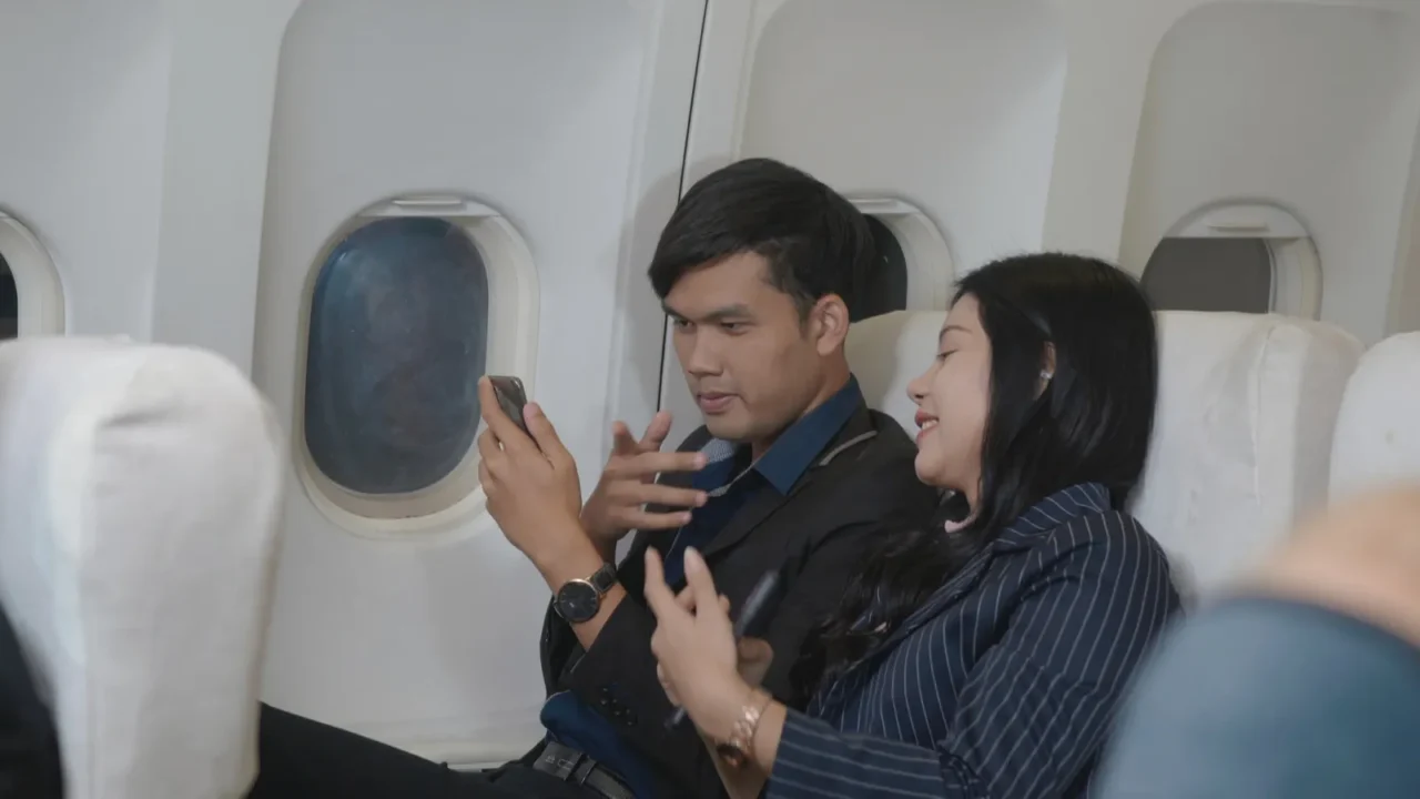 happy asian young people couple passenger traveling airplane sitting on