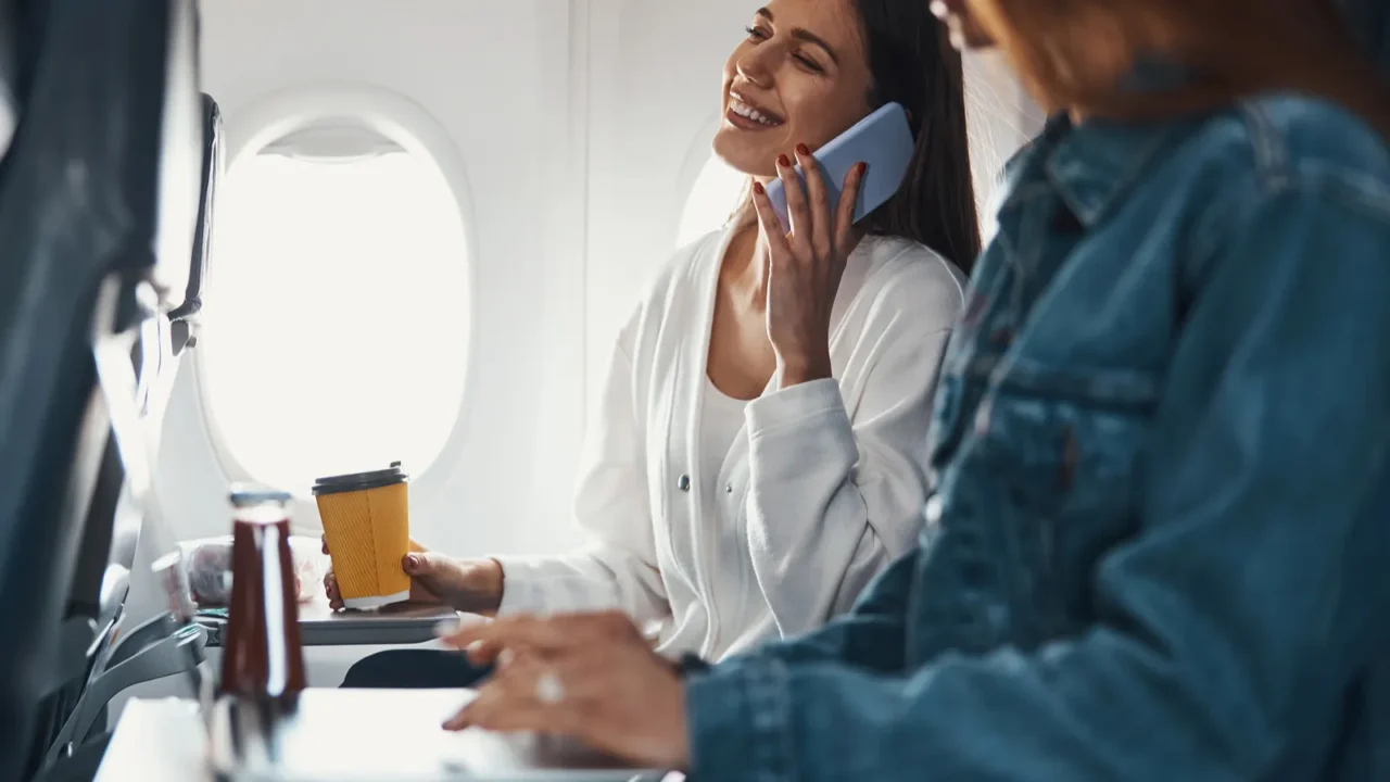 happy lady calling someone on the phone from airplane