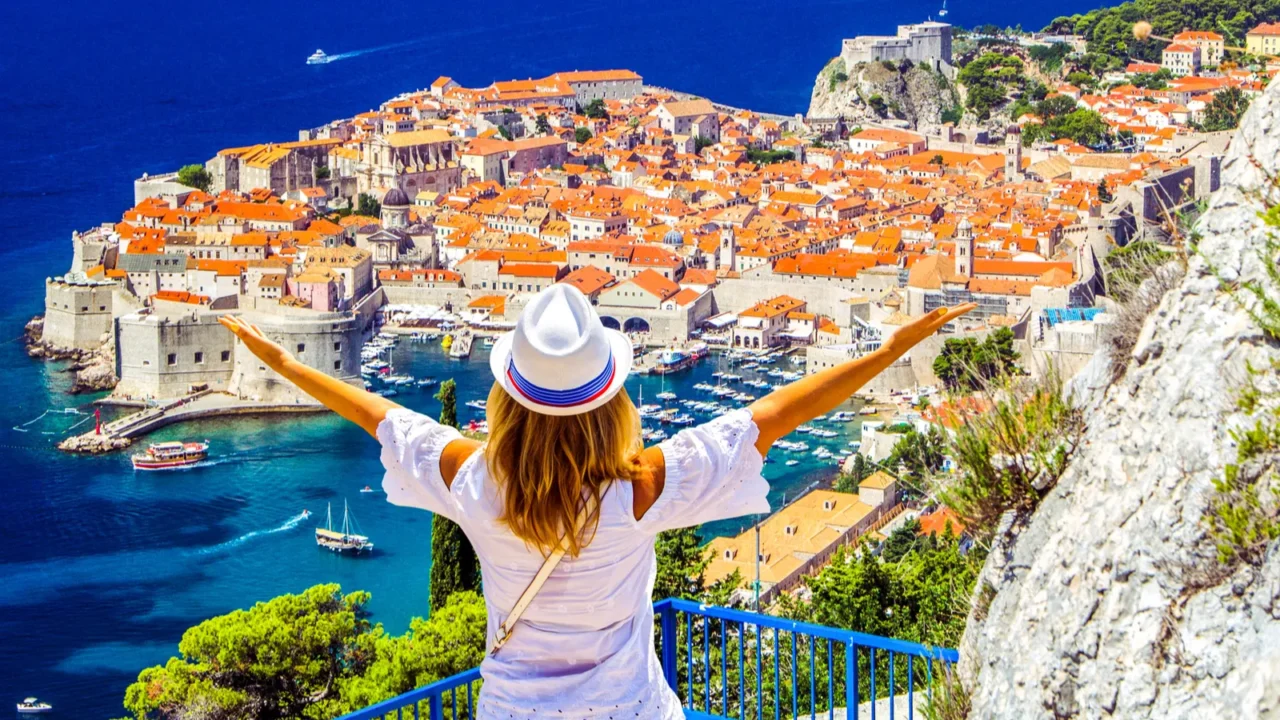 happy young girl enjoys view of old town medieval ragusa