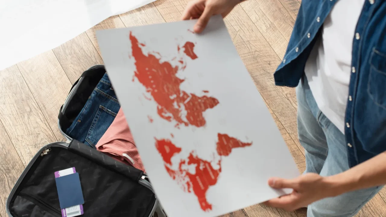 high angle view of passport in suitcase near blurred man