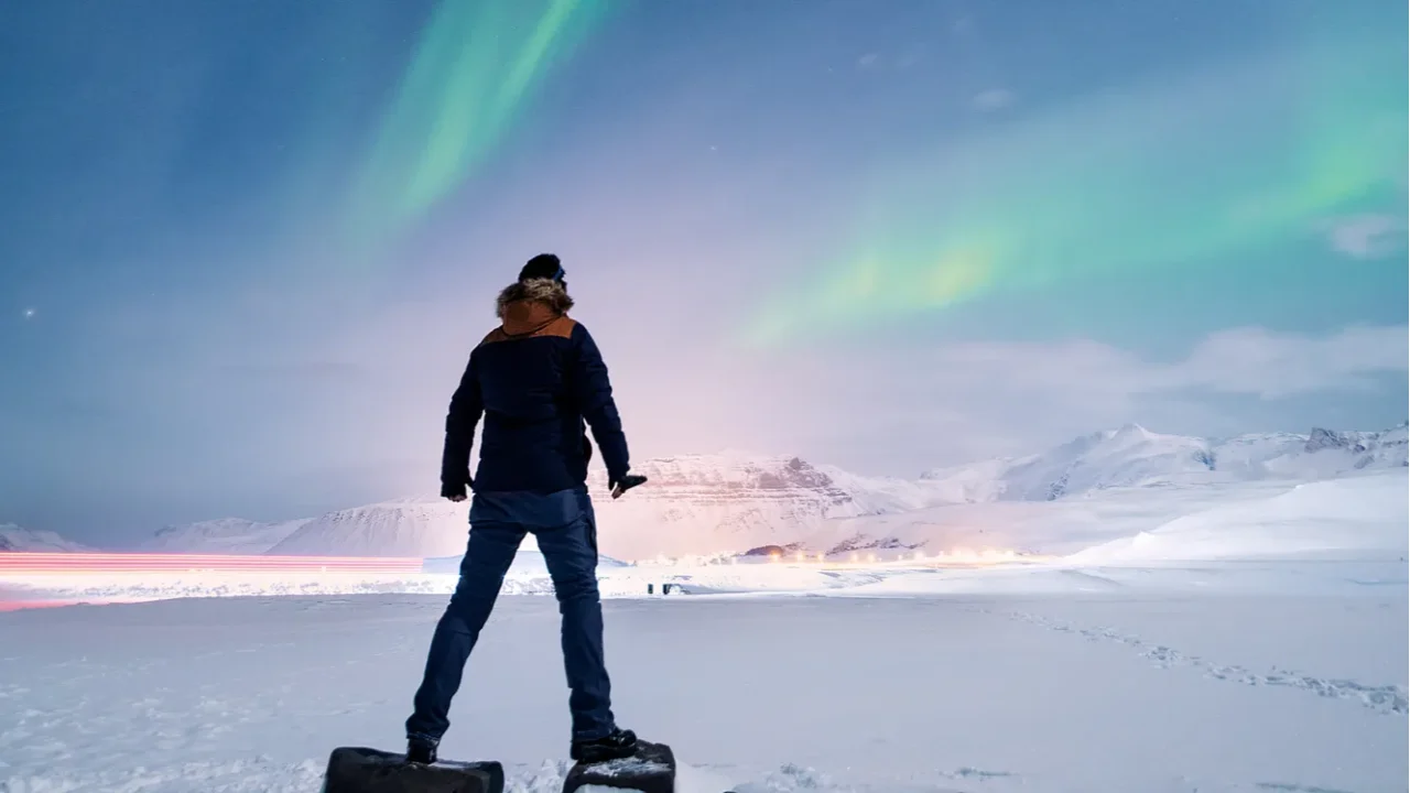 lone man hiker gazing at the aurora borealis northern lights