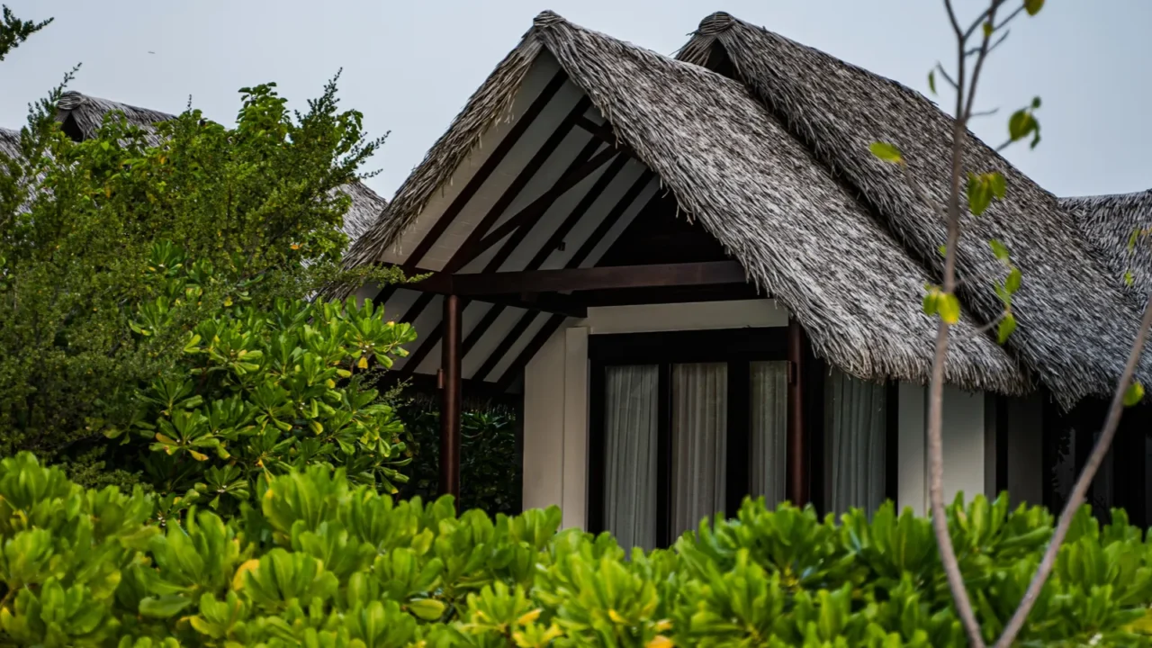 luxury tropical villa with traditional thatched roof nestled among lush