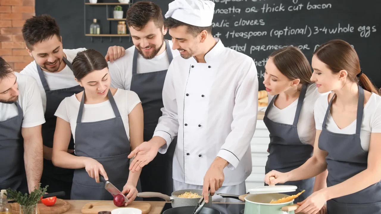 male chef and group of young people during cooking classes