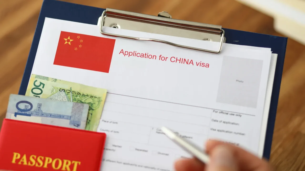 male hand hold silver pen with passport filling china apllication