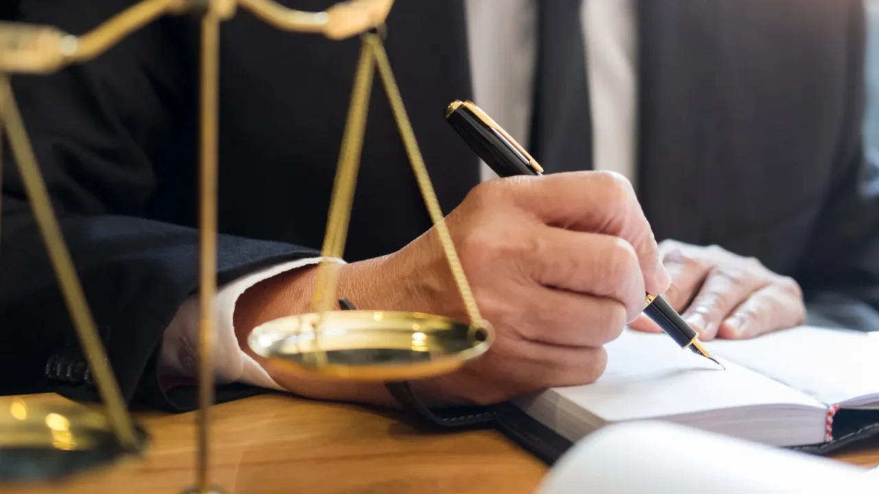 male lawyer working with contract papers and reading law book