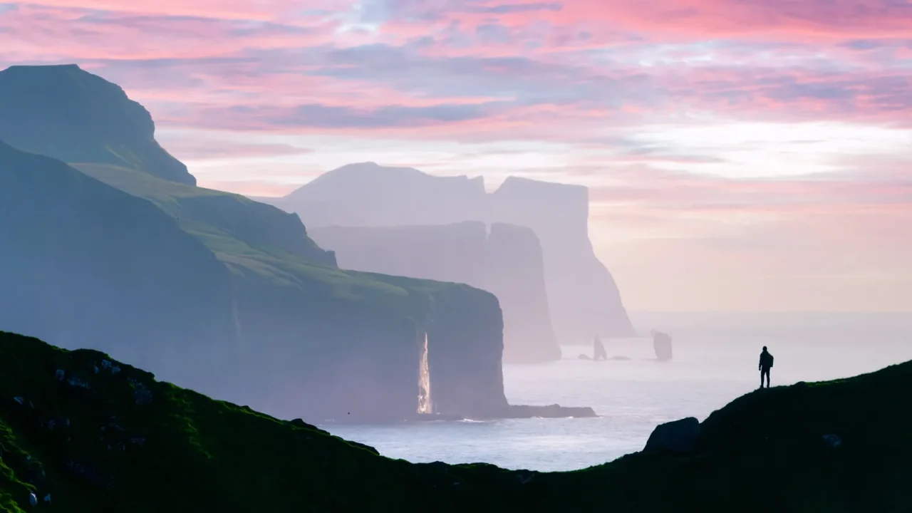 man silhouette on background of famous risin og kellingin rocks