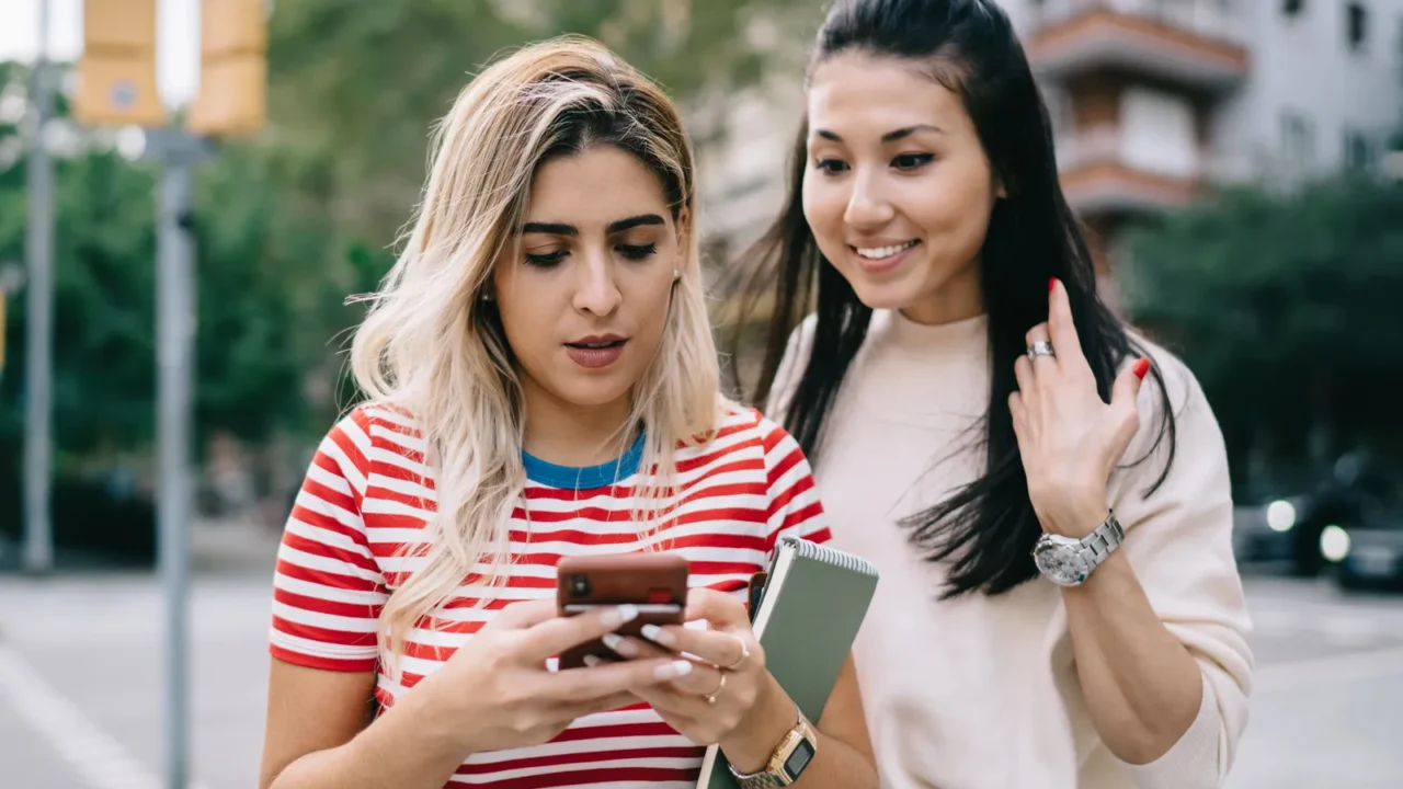 multiracial hipster girls enjoying mobility chatting and messaging during city