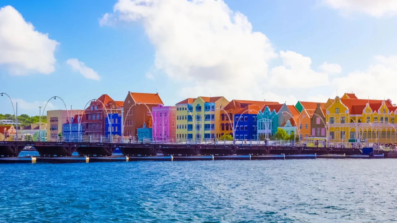 people at queen emma bridge in front of punda district