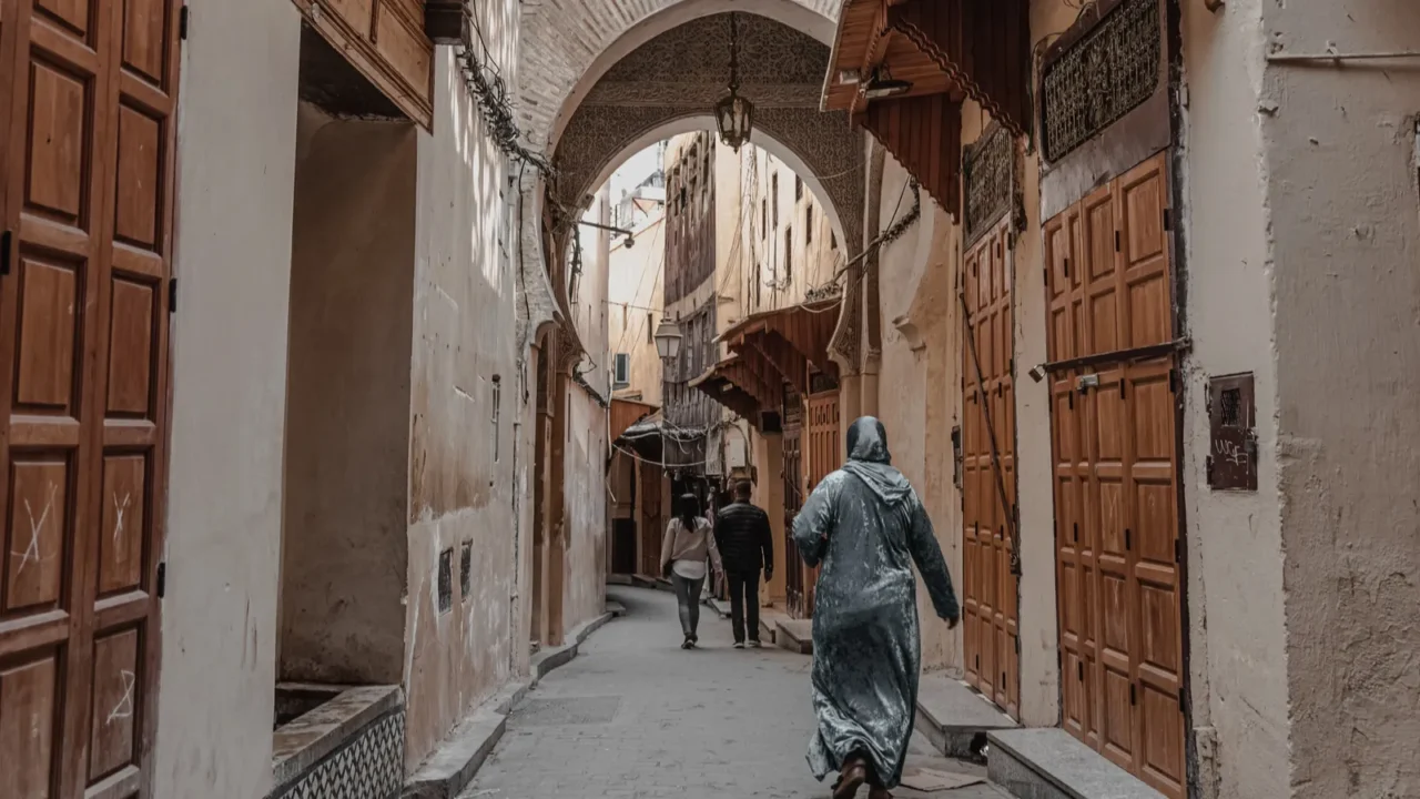 people walking through an empty street in the old medina