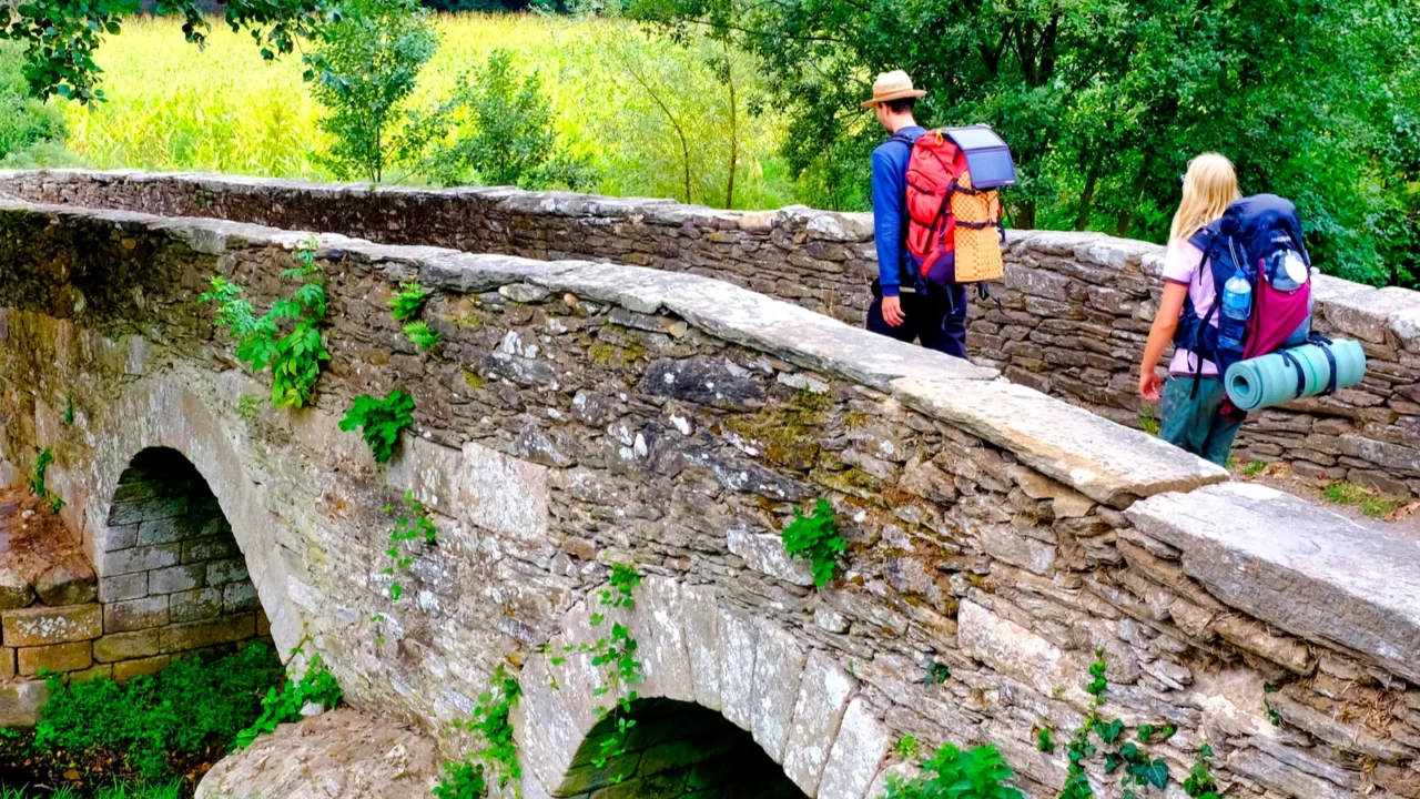 pilgrims on the ponte da aspera on the camino de