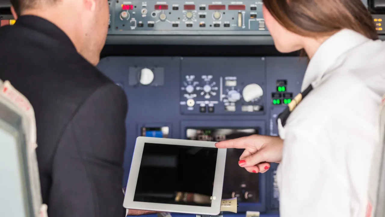 pilot and copilot checking flight information on digital tablet