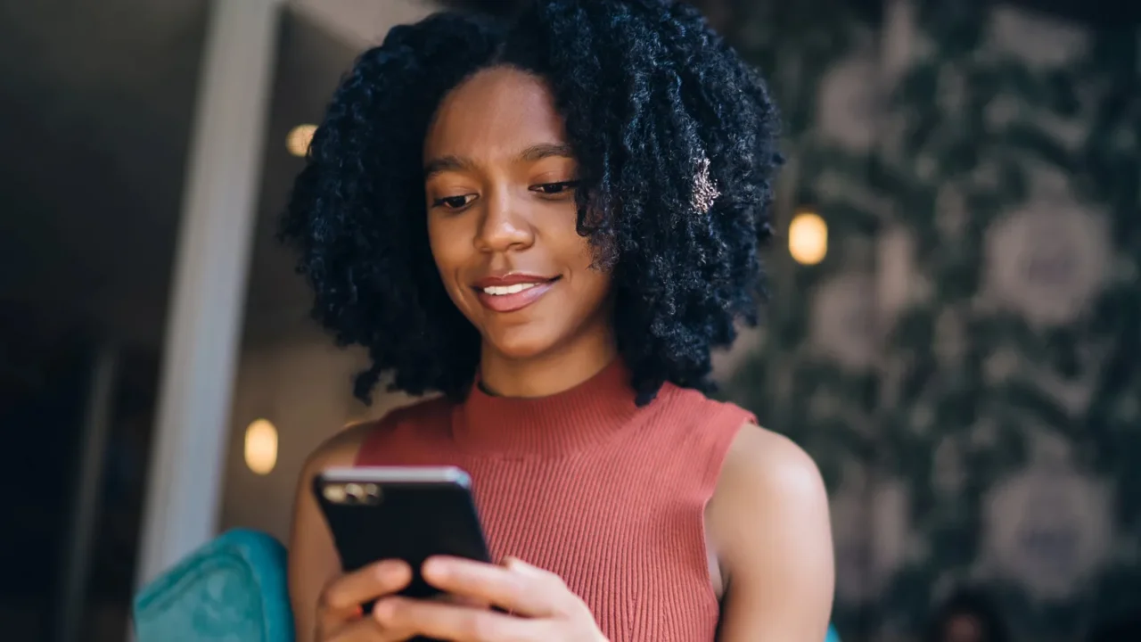 positive black hipster girl typing text message for sending to