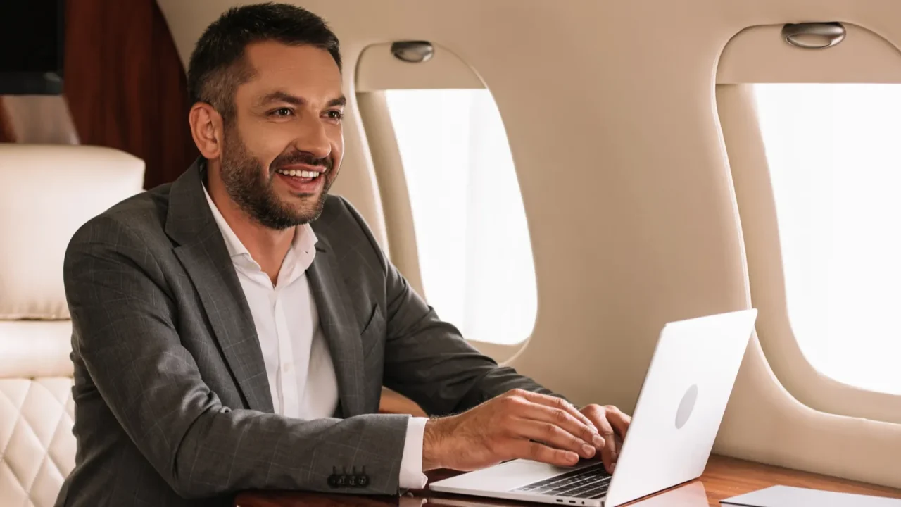 selective focus of happy bearded businessman using laptop in first