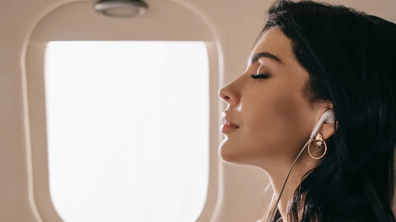 side view of attractive businesswoman with closed eyes listening music