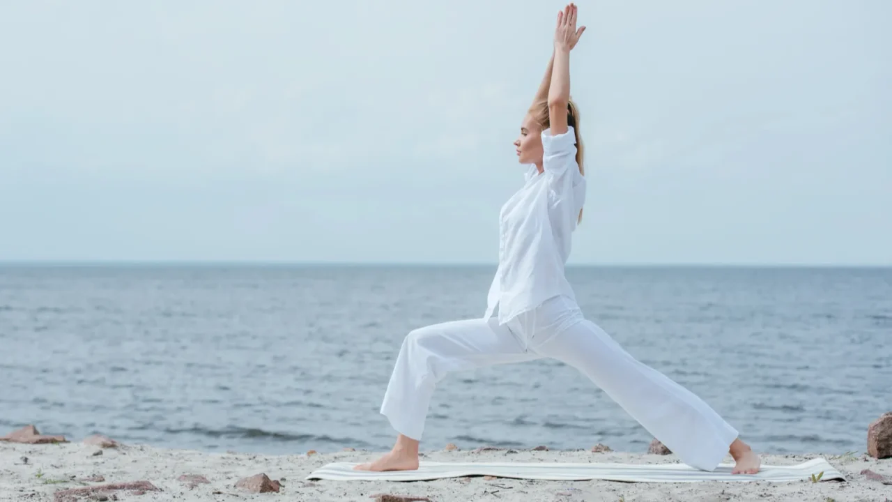 side view of blonde woman practicing yoga near river