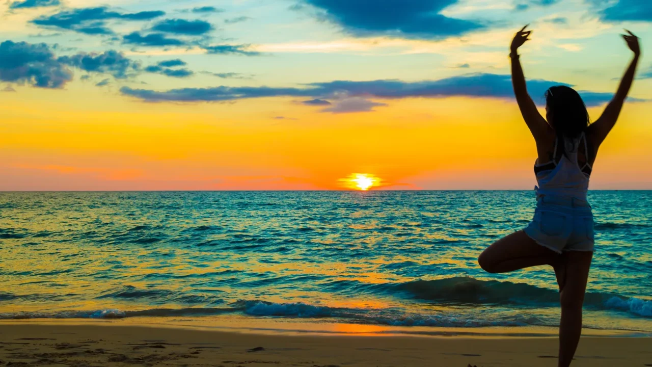 silhouette woman with yoga posture on the sea beach