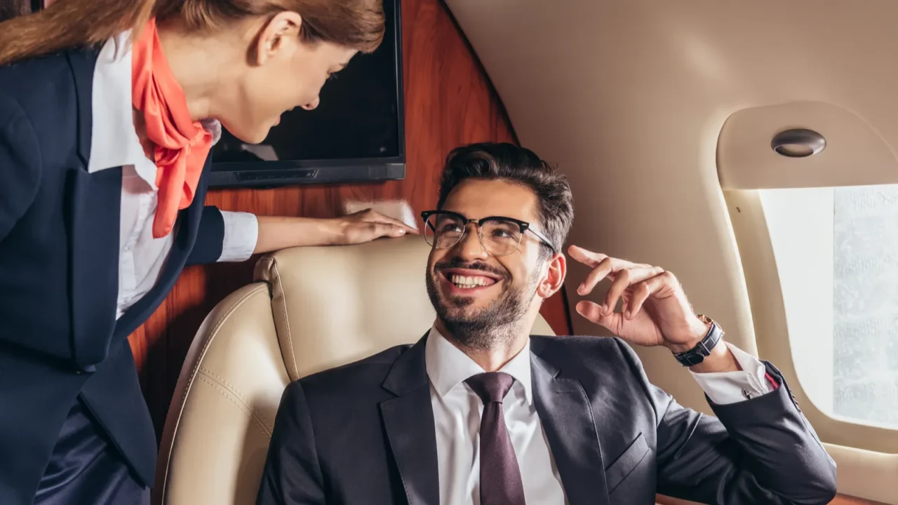 smiling businessman in suit looking at flight attendant in private