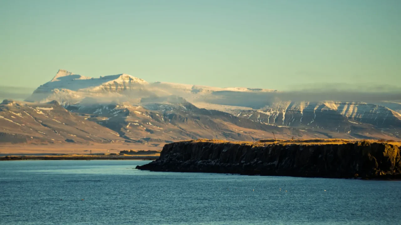 snowcapped mountains and rocky coastline under clear winter light