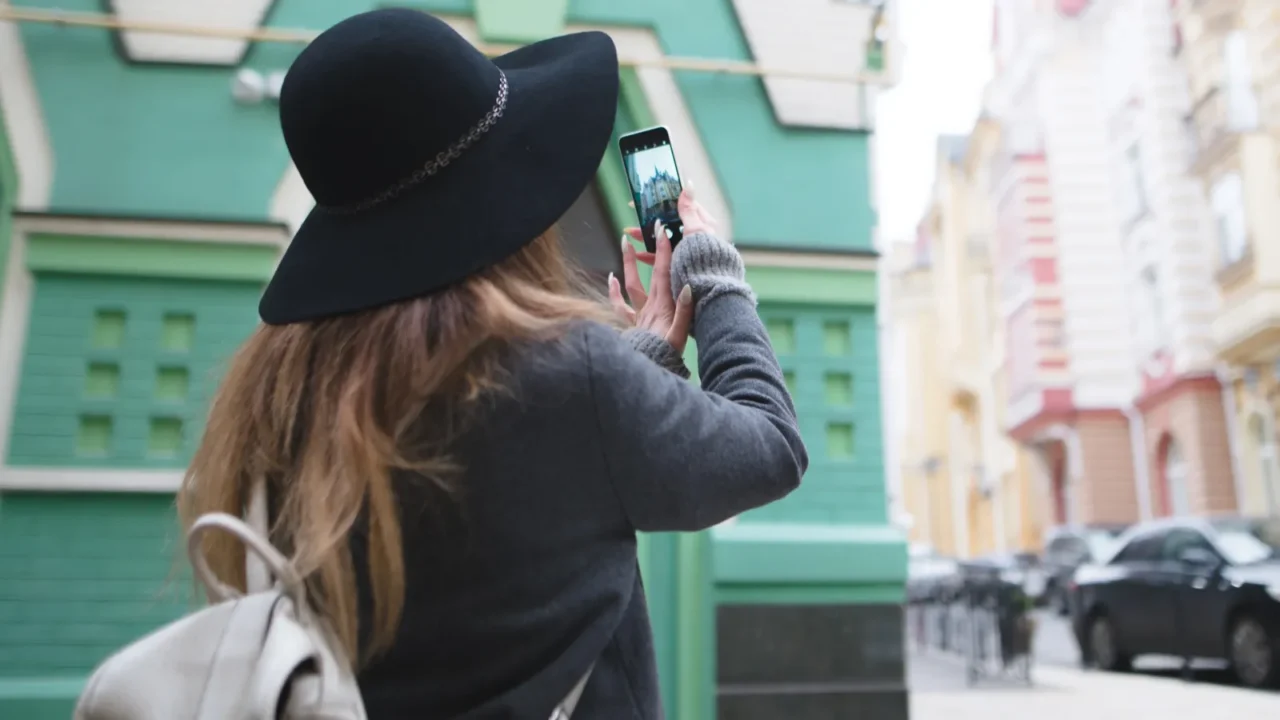 stylish beautiful girl photographing a street photo on the phone