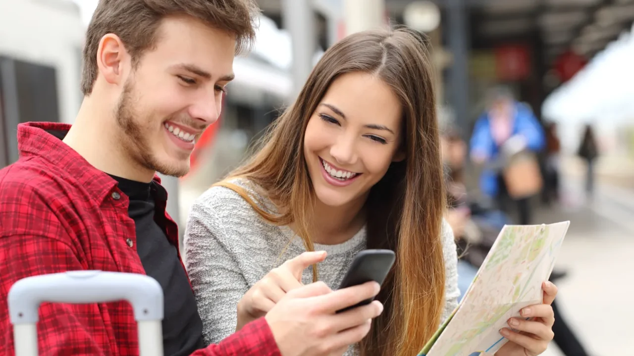 tourists travelers consulting gps and guide in a train station