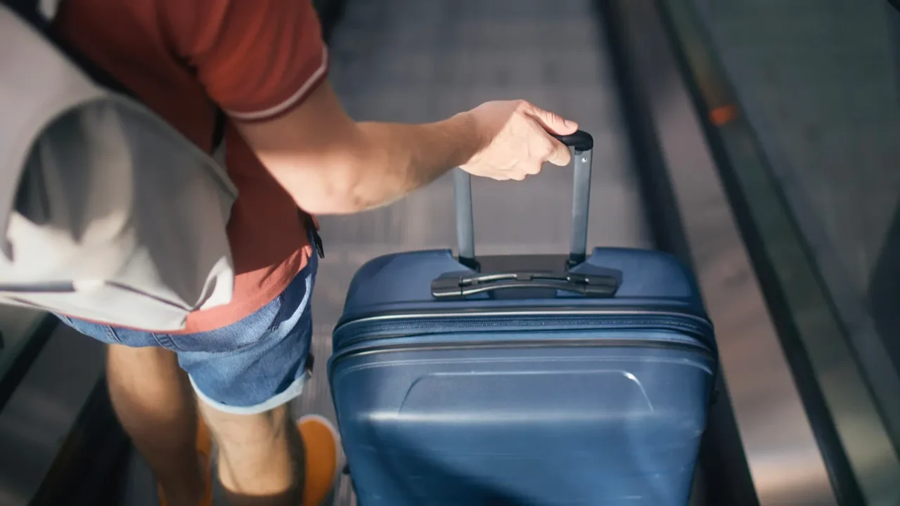traveler walking through airport terminal rear view of man with
