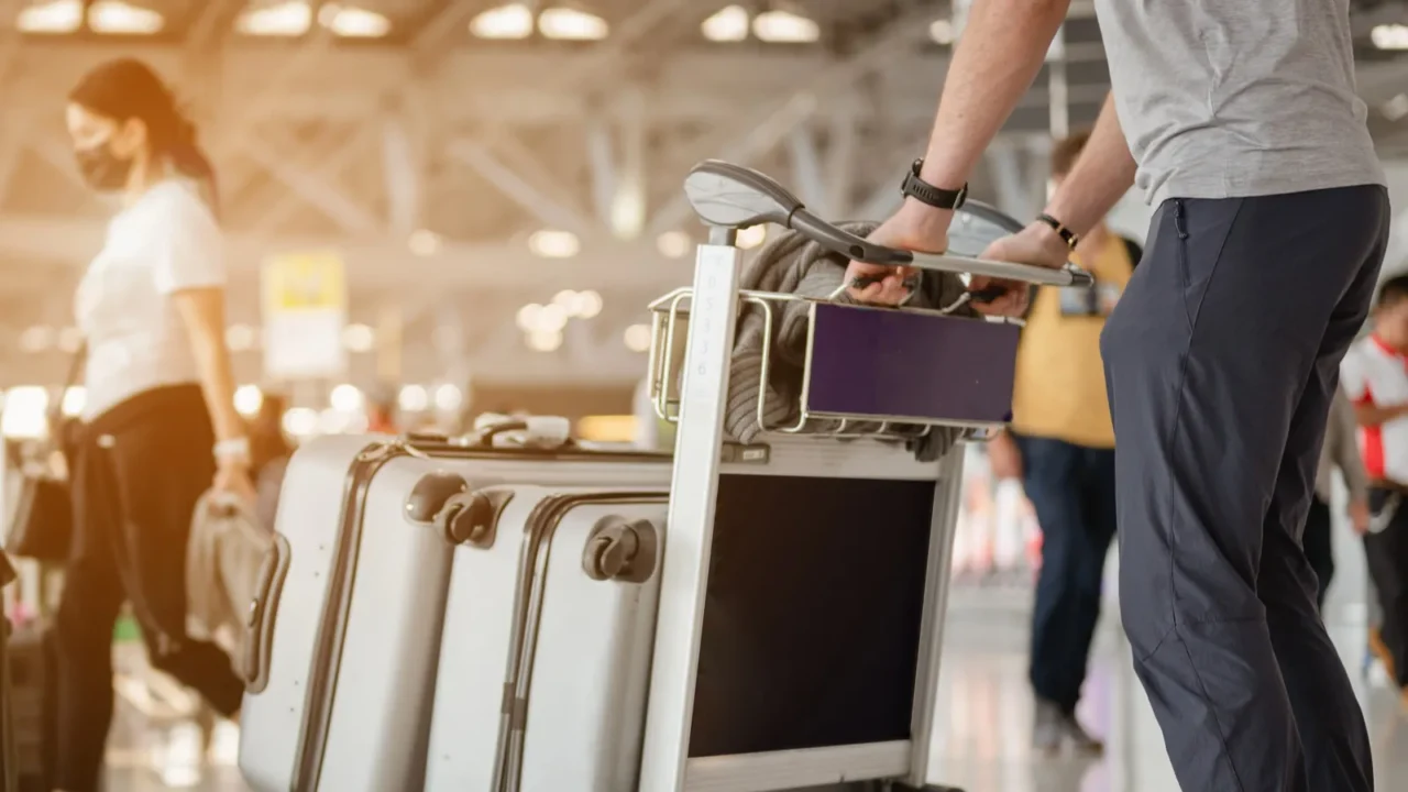 travelers are walking to drag luggage in modern airport terminal