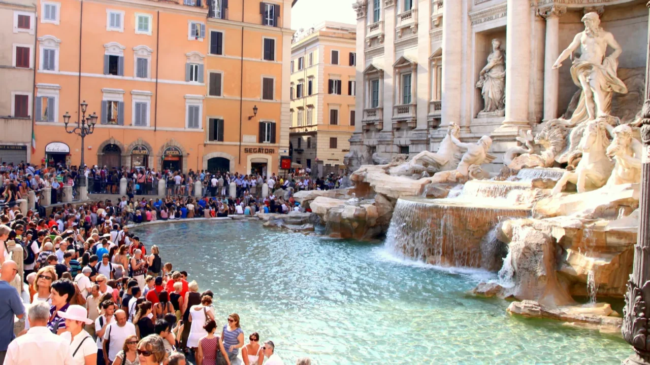 A view of the Trvi Fountain Square in a busy summer day.