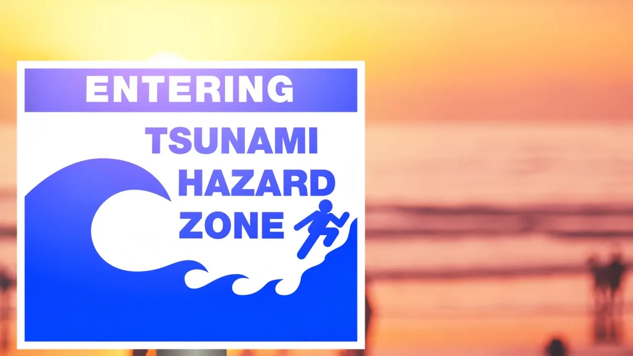 tsunami warning sign on blur people relax on tropical sunset