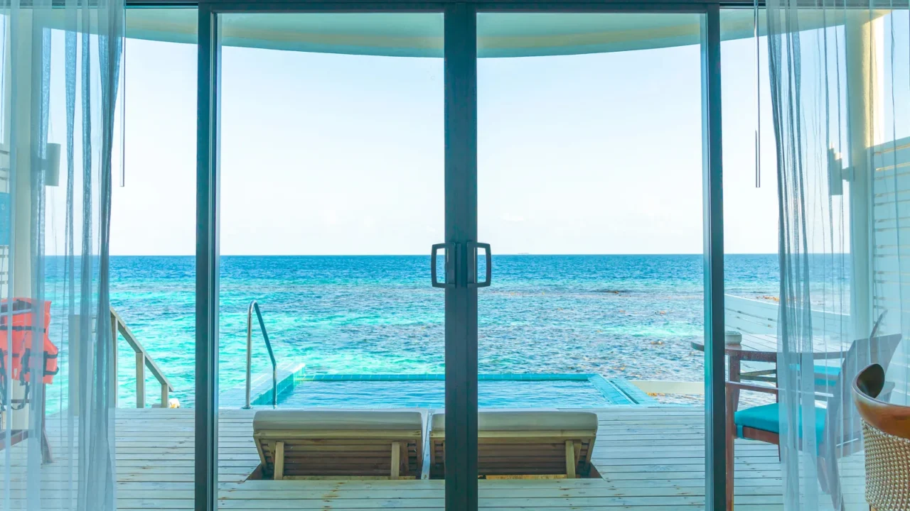 window with pool and sea background view from bed