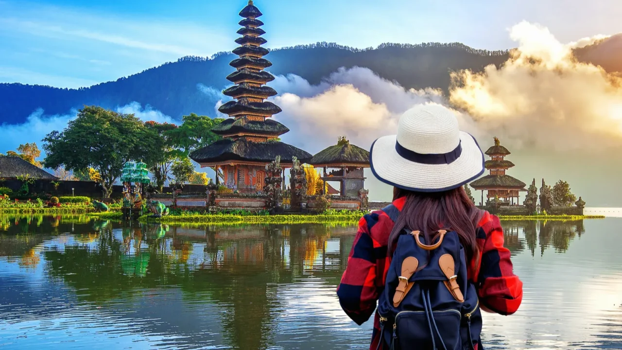 woman traveler with backpack looking to pura ulun danu bratan