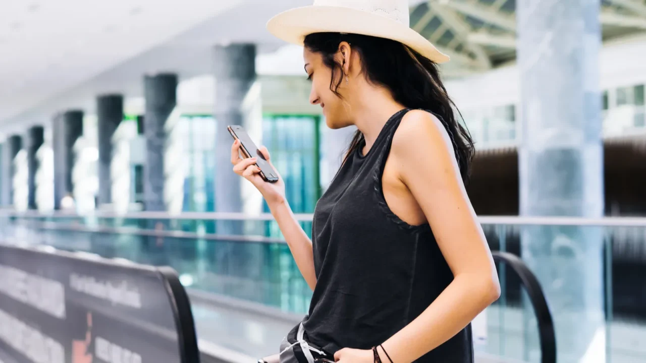 woman with smartphone at airport young traveler checking boarding time