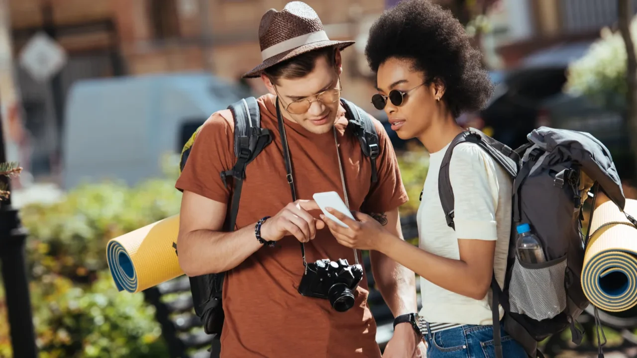 young couple of tourists with smartphone looking for destination