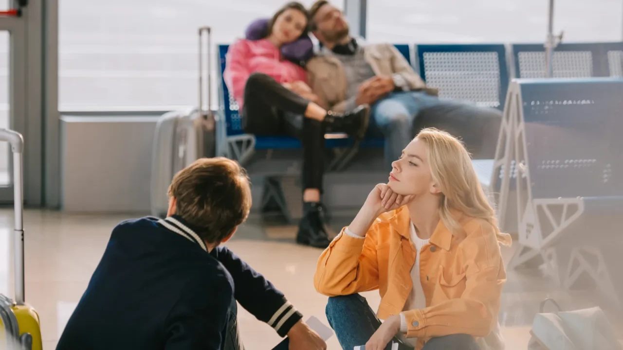 young people with luggage waiting in airport terminal