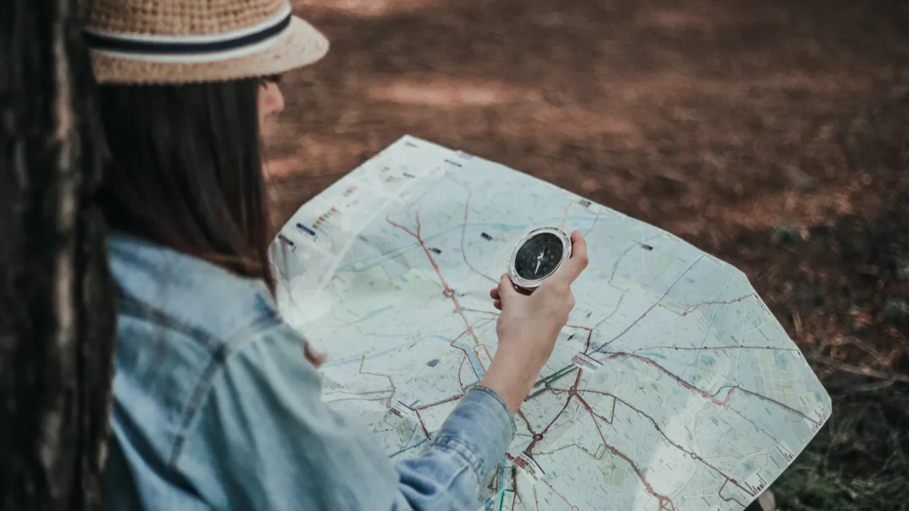 young teenage girl hiker with map in wood