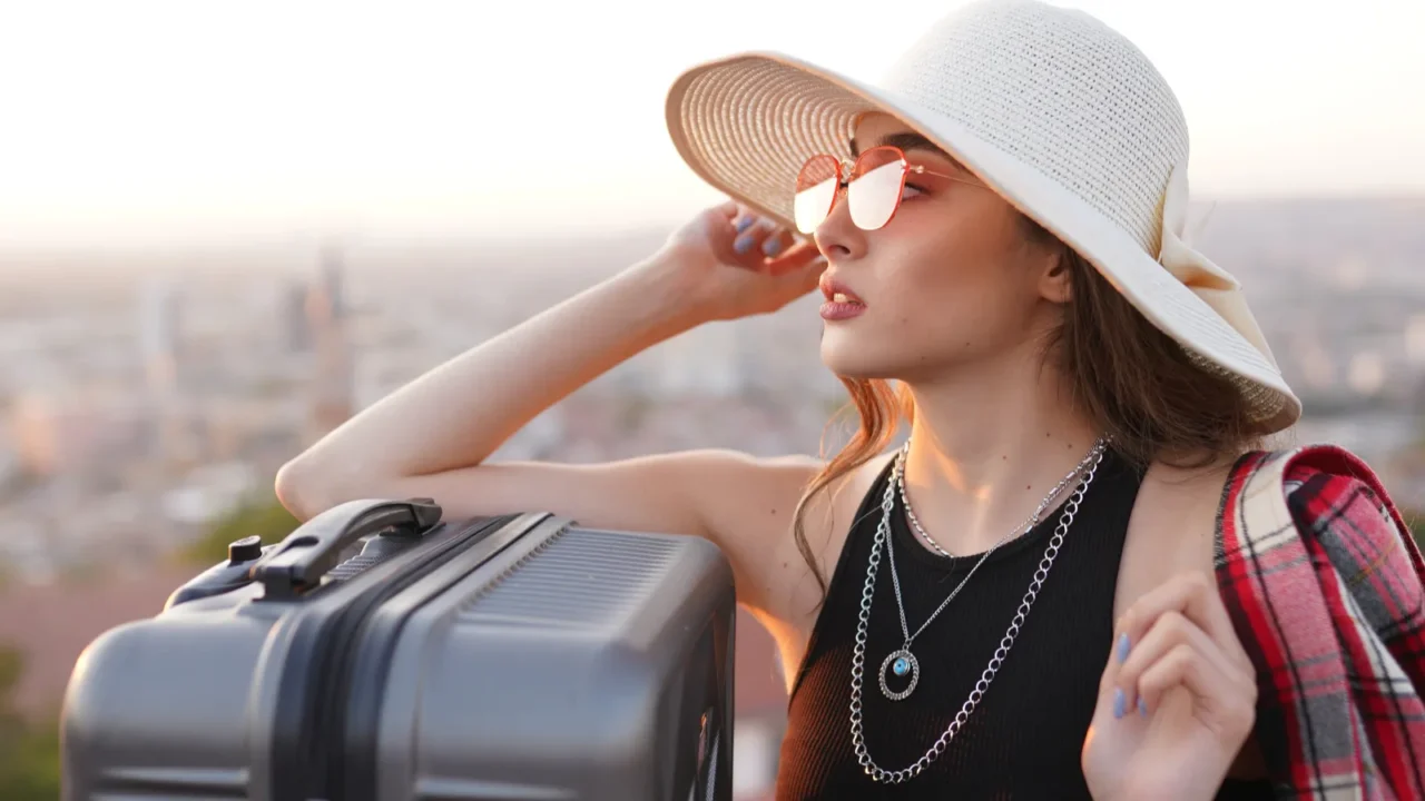 young woman in straw hat and sunglasses with suitcase