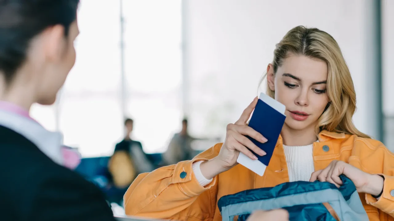 young woman putting passport with boarding pass into bag at