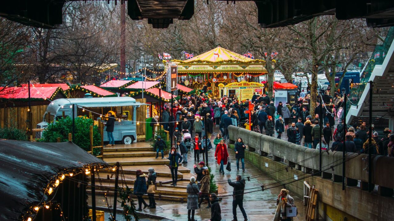 Winter Christmas market in Southbank, London. People eating, drinking and having fun with friends and family.
