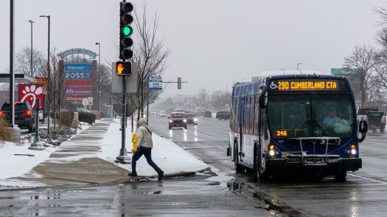 Man getting of the bus during winter storm on Touhy Ave in Niles, Illinois, United States.