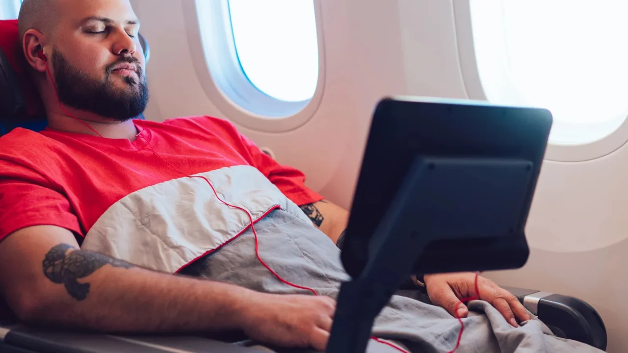 30 years old caucasian man sleeping on wide seat cowered