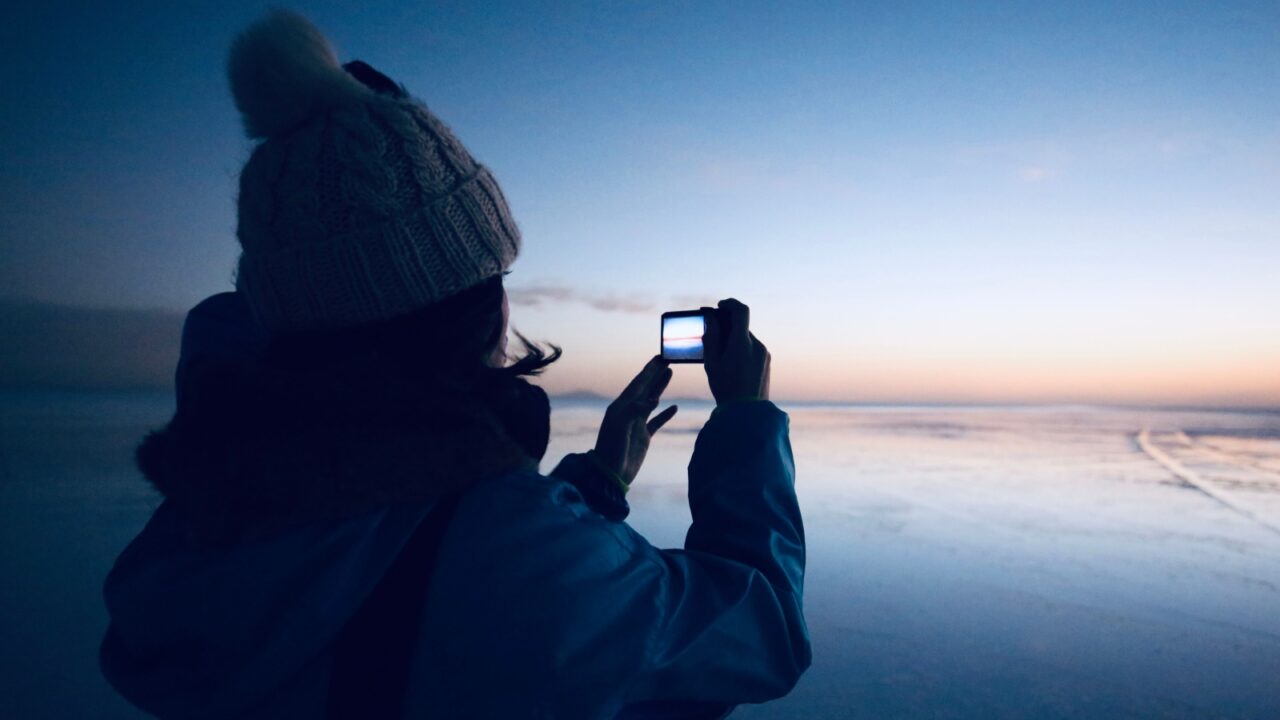 A woman taking pictures of the sunrise of Uyuni Salt Lake