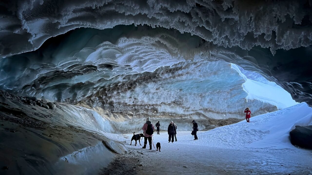 Castner Cave, Alaska - January 14, 2022: People and dogs inside Castner Cave, an ice cave in Alaska on a winter day.