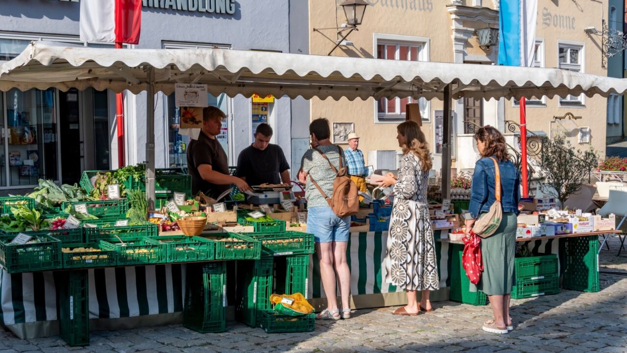 Wending, Germany - jul 05, 2025: people shop at a fresh fruit stand at a small village market in the town of Wending in Bavaria.