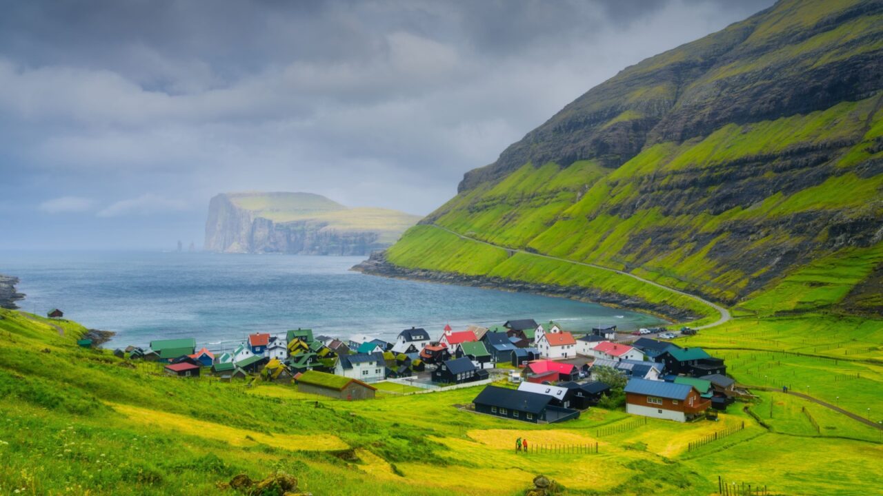 Tjornuvik village, Streymoy Island, Faroe Islands, Denmark. Scenic place for travel. Panoramic view of the village, sea bay and mountains. Photography for wallpaper and postcards.