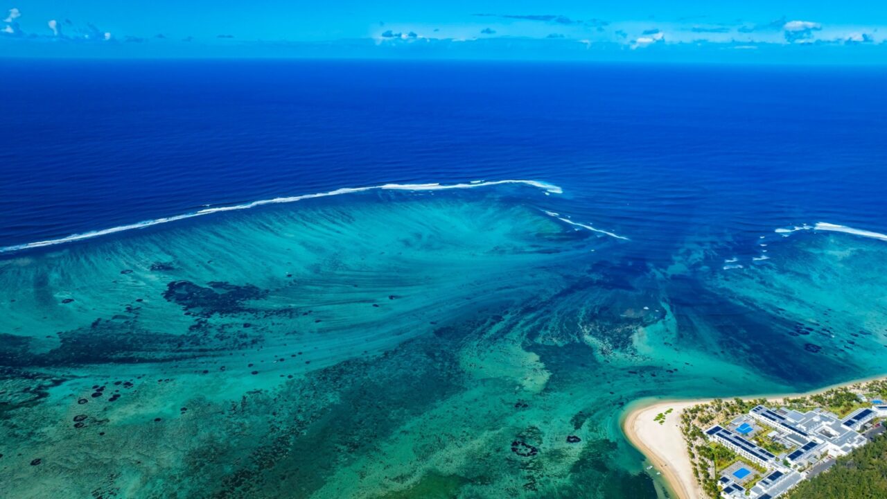 Aerial view of Mauritius island and Le Morne Brabant mountain with beautiful blue lagoon and underwater waterfall illusion background